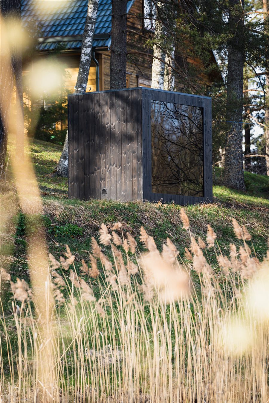 ROYAL M four-person outdoor sauna cabin in a garden setting